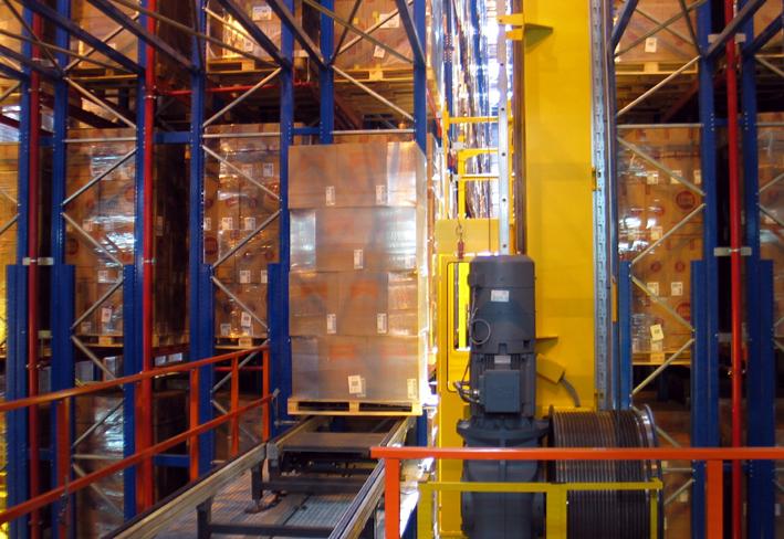 Stacker crane handling a pallet inside a high-bay automated storage aisle