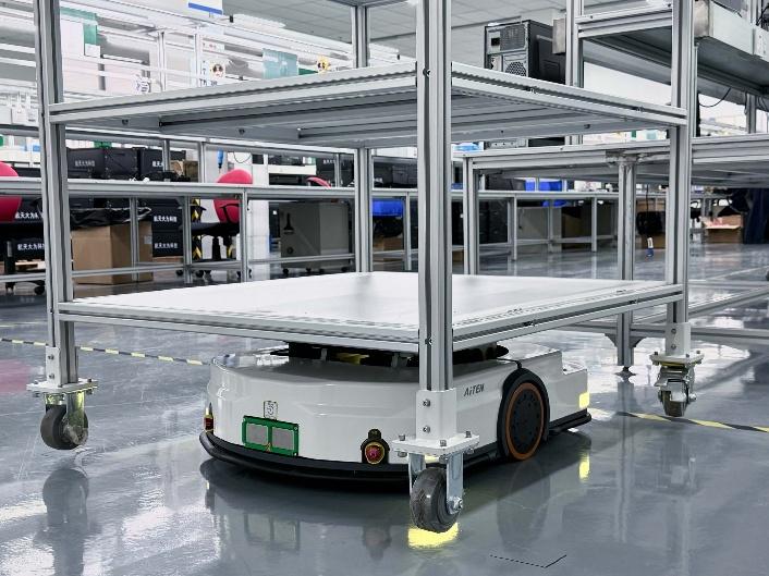 Autonomous mobile robot transporting a wheeled metal cart